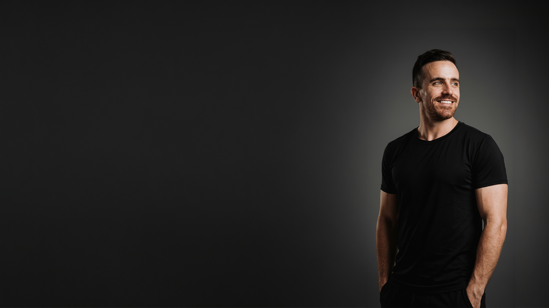 Ricardo Prosperi, smiling in a dark studio portrait.